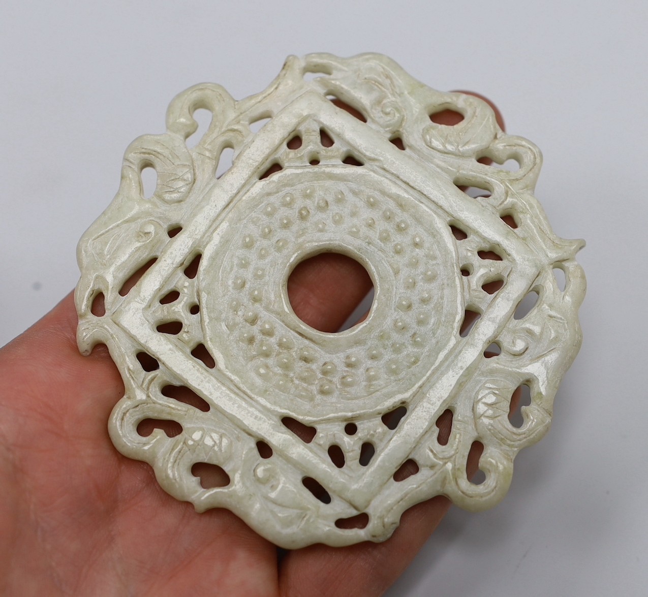 A Chinese pale celadon jade archaistic plaque (huang), a similar plaque and a bowenite jade disc